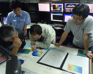 事前調査で作成した海底地形図から潜航するコースを検討する研究者チーム。